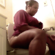 A big, black woman sits on a toilet, takes an explosive, wet shit, then stands up to wipe herself. She reacts to the smell by holding her nose. About 6 minutes.